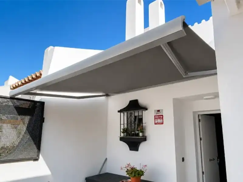 Toldo cofre con lonas grises instalado en una vivienda de la costa de Granada
