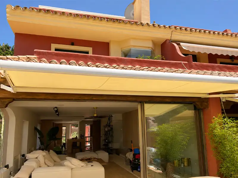 Toldo cofre con lona arena en una terraza de Málaga
