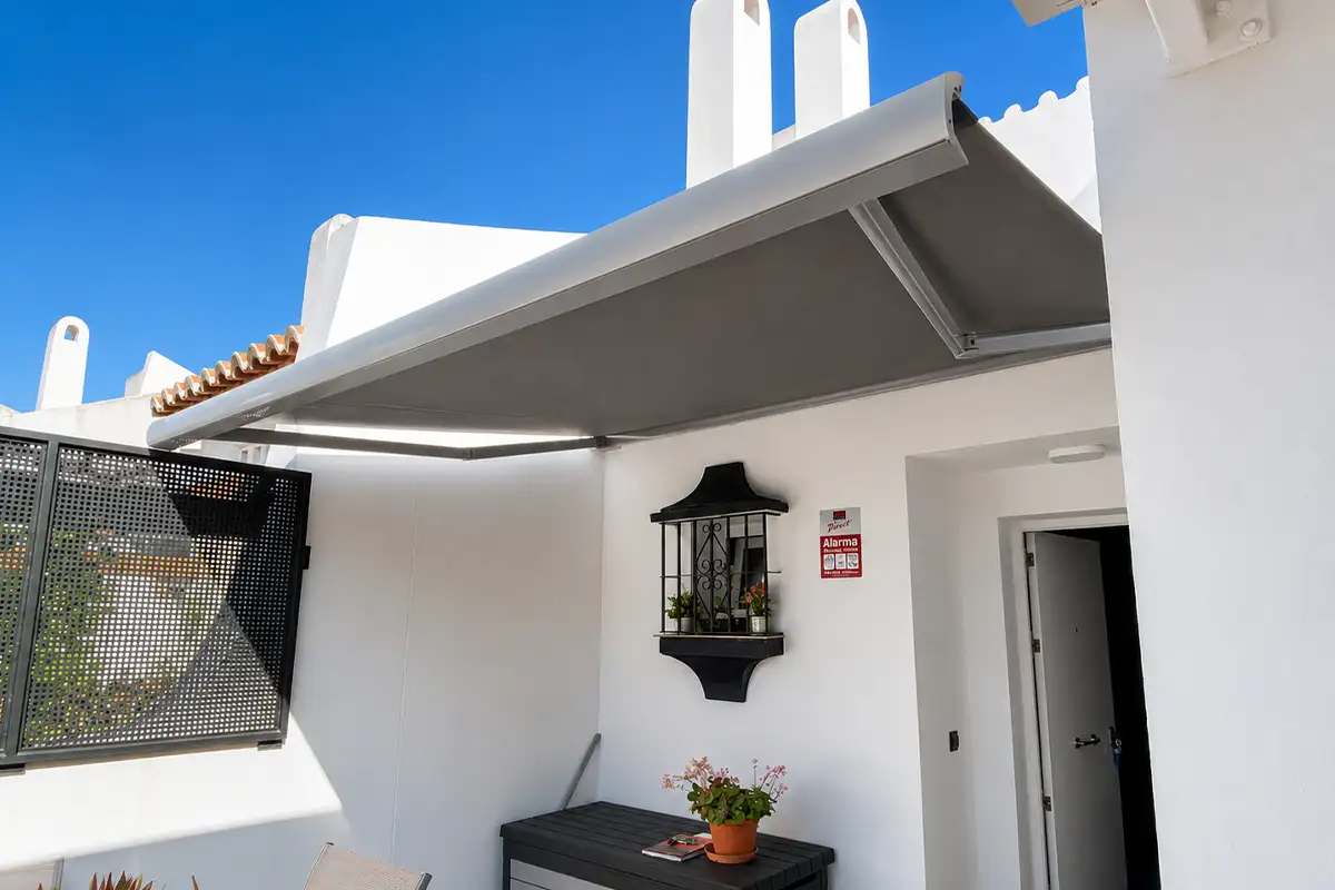 Toldo cofre con lona gris instalado en la terraza de una vivienda de Málaga