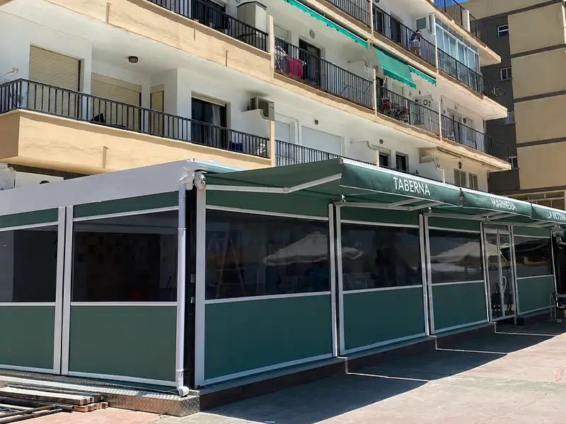 Toldo cortavientos con guías en la terraza de un restaurante de Málaga