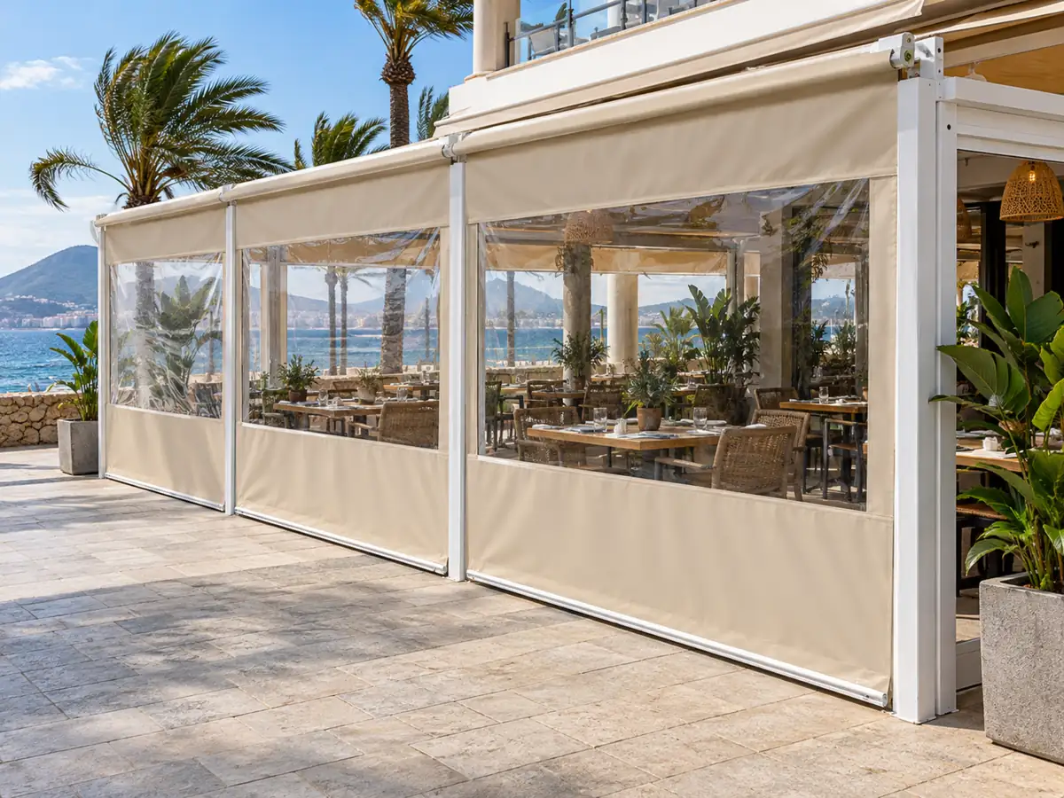 Cortavientos para terrazas de restaurante Cortavientos con ventanas transparentes protegiendo del viento las mesas de un restaurante en el paseo marítimo