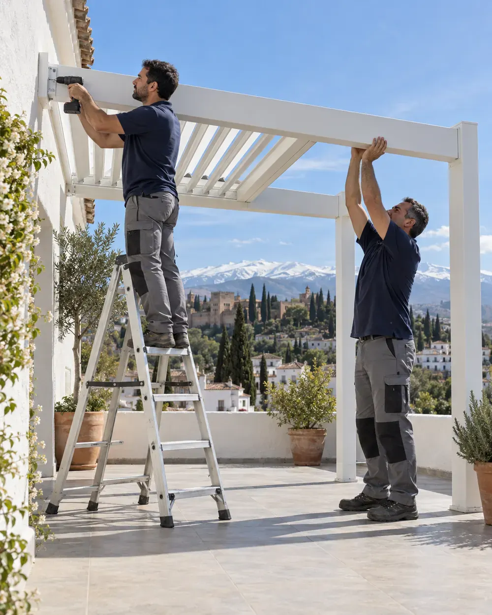 Instalación de pérgolas bioclimáticas en Granada Instaladores montando una pérgola bioclimática de lamas orientables en una terraza de Granada con Sierra Nevada al fondo