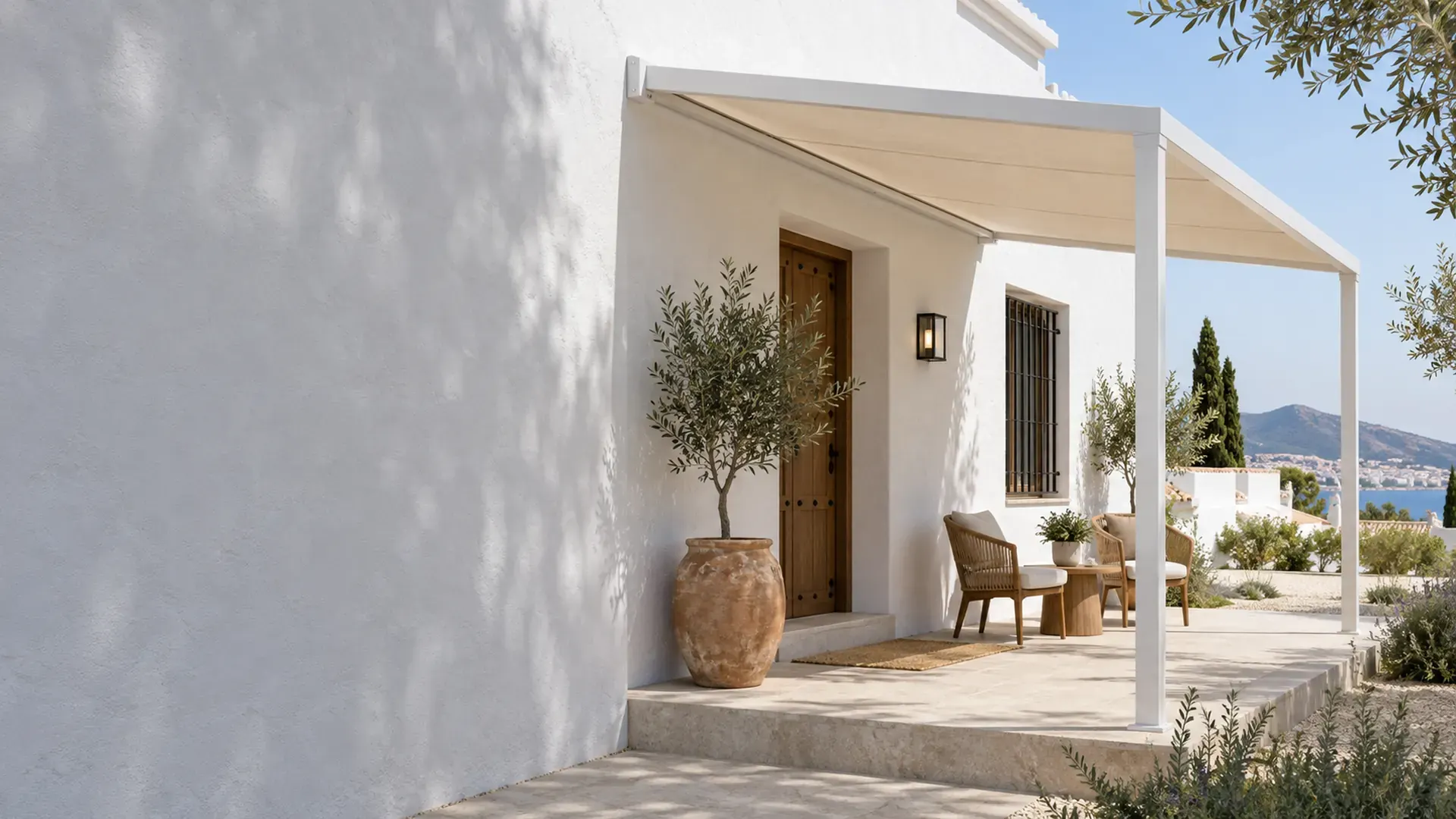 Pérgolas adosadas en Málaga Pérgola adosada en Málaga: pérgola de aluminio blanco con lona sobre el porche de una casa con vistas al mar