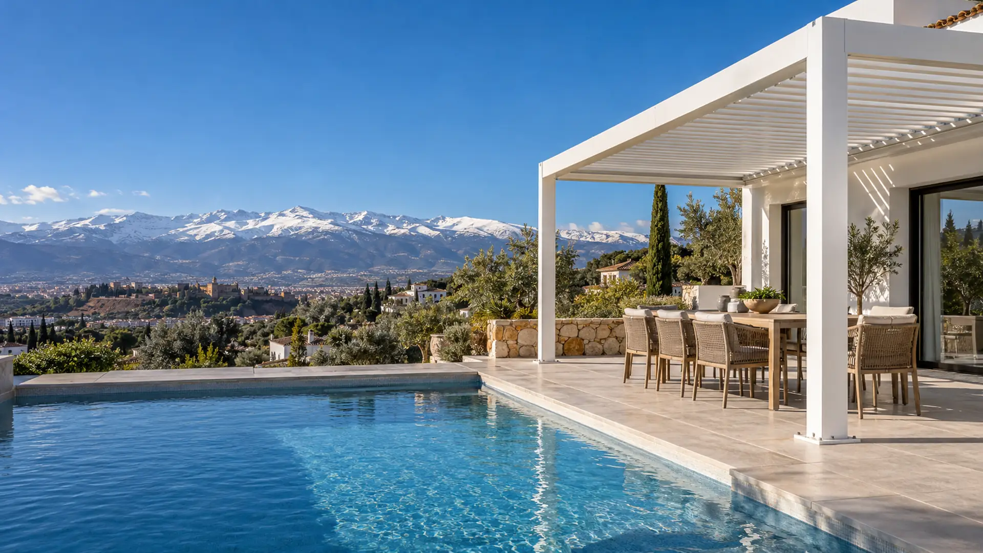 Pérgolas en Granada: pérgola de aluminio junto a la piscina de un chalet con Sierra Nevada al fondo