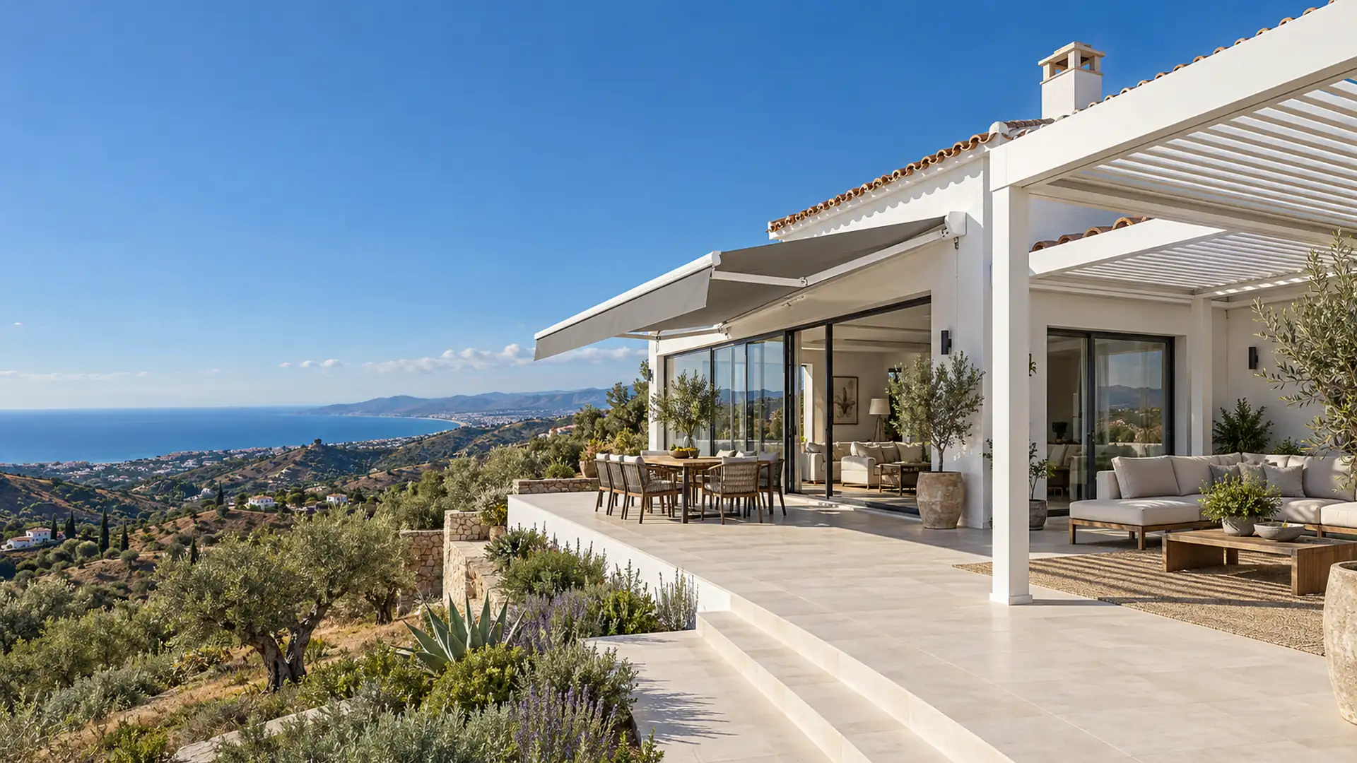 Servicios de toldos y pérgolas: toldo articulado y pérgola bioclimática de lamas en la terraza de un chalet de la Axarquía con vistas al mar