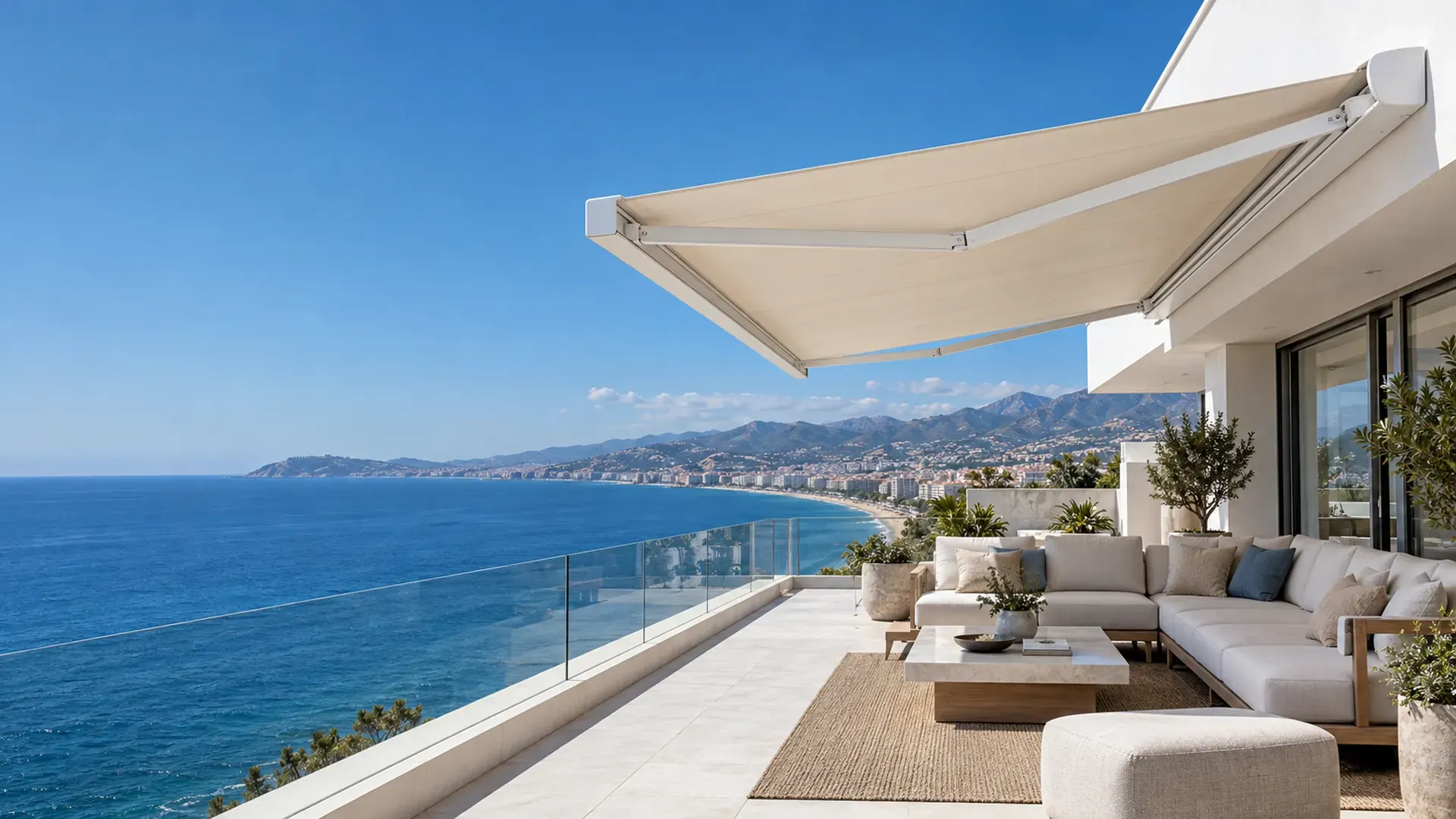 Toldo cofre en Málaga con lona beige extendido en un ático en primera línea de playa con vistas a la bahía