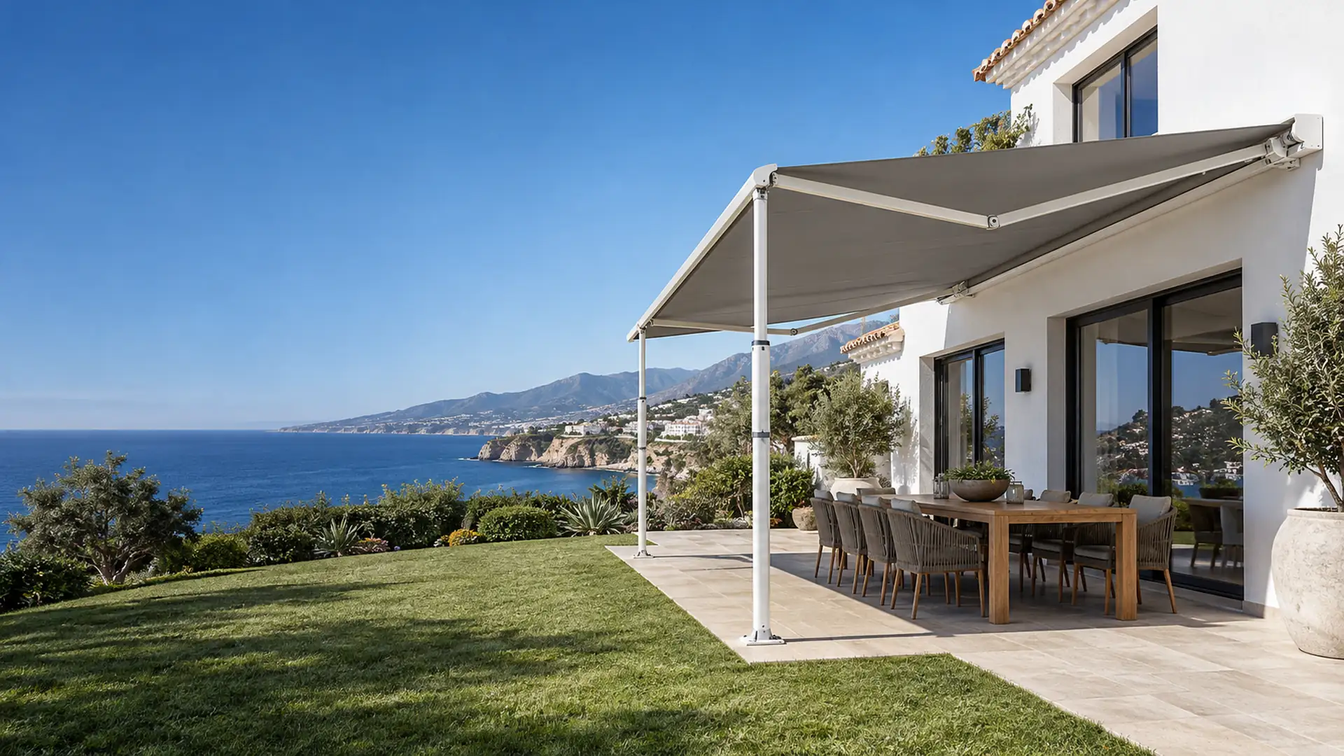 Toldo con patas telescópicas en Málaga: toldo articulado con lona gris en el jardín de una casa en Nerja con vistas al mar