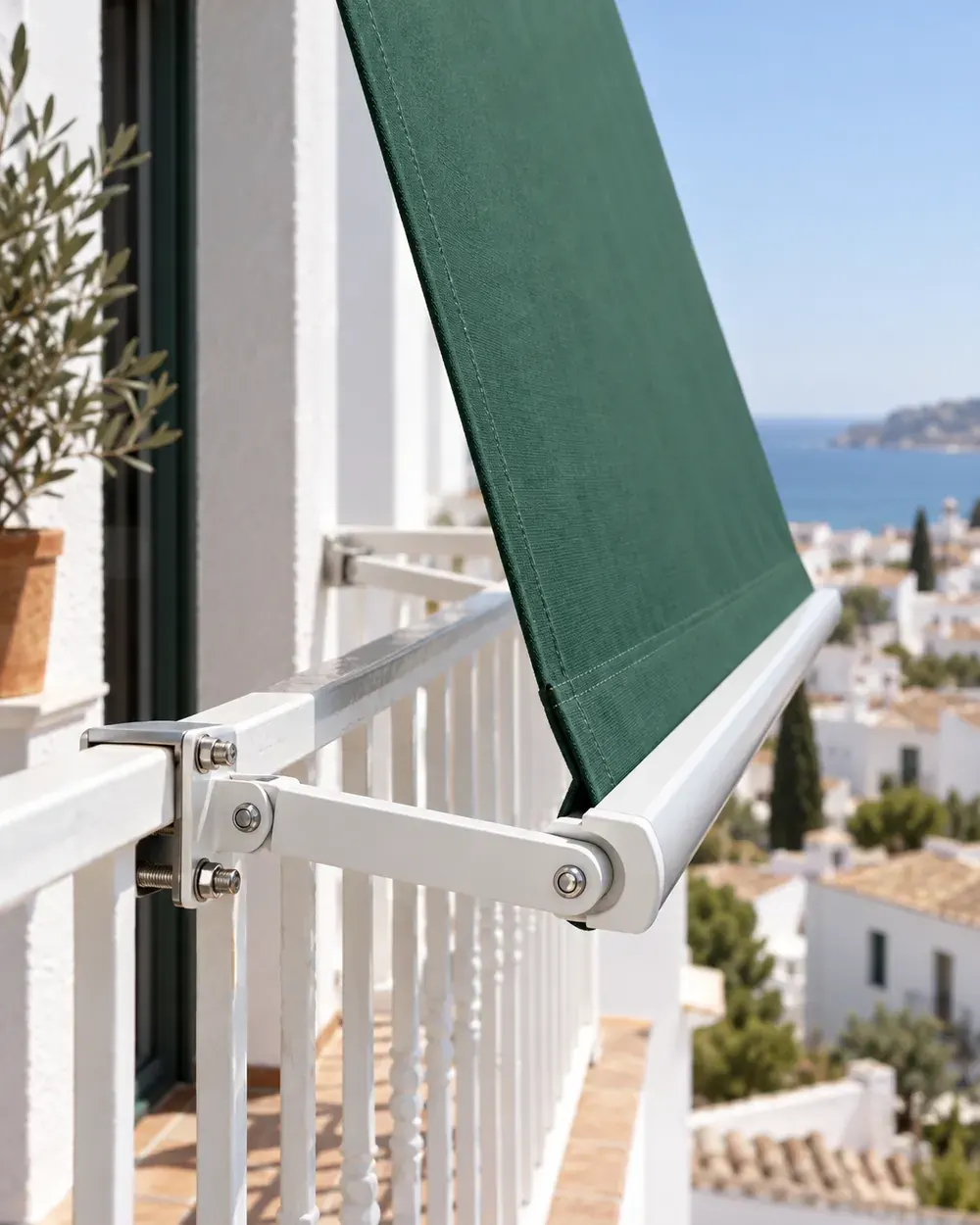 Toldo stor con brazos abatibles Brazo abatible de aluminio blanco de un toldo stor con lona verde en la barandilla de un balcón