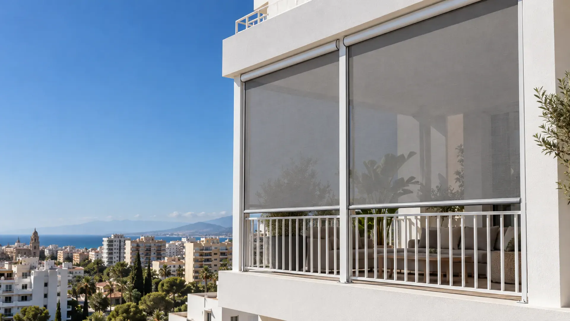Toldo vertical en Málaga: toldos verticales de tejido screen gris bajados en la terraza de un piso con vistas al mar