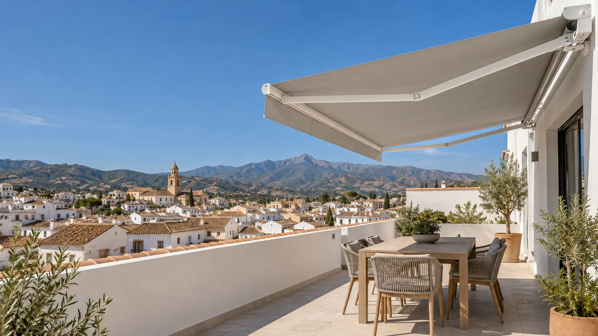 Toldos a medida en Málaga: toldo articulado con lona gris extendido en un ático de Vélez-Málaga con vistas al casco antiguo