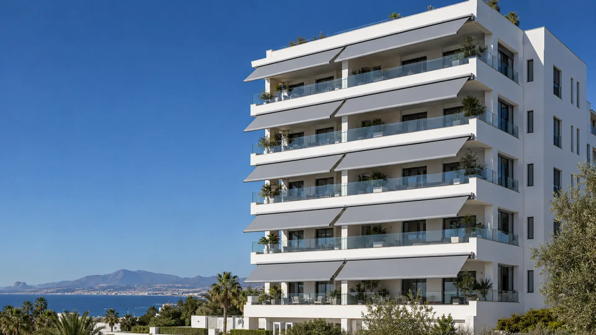 Toldos para comunidades de vecinos en Málaga Toldos para comunidades de vecinos en Málaga: edificio con el mismo modelo de toldo gris en todos los balcones